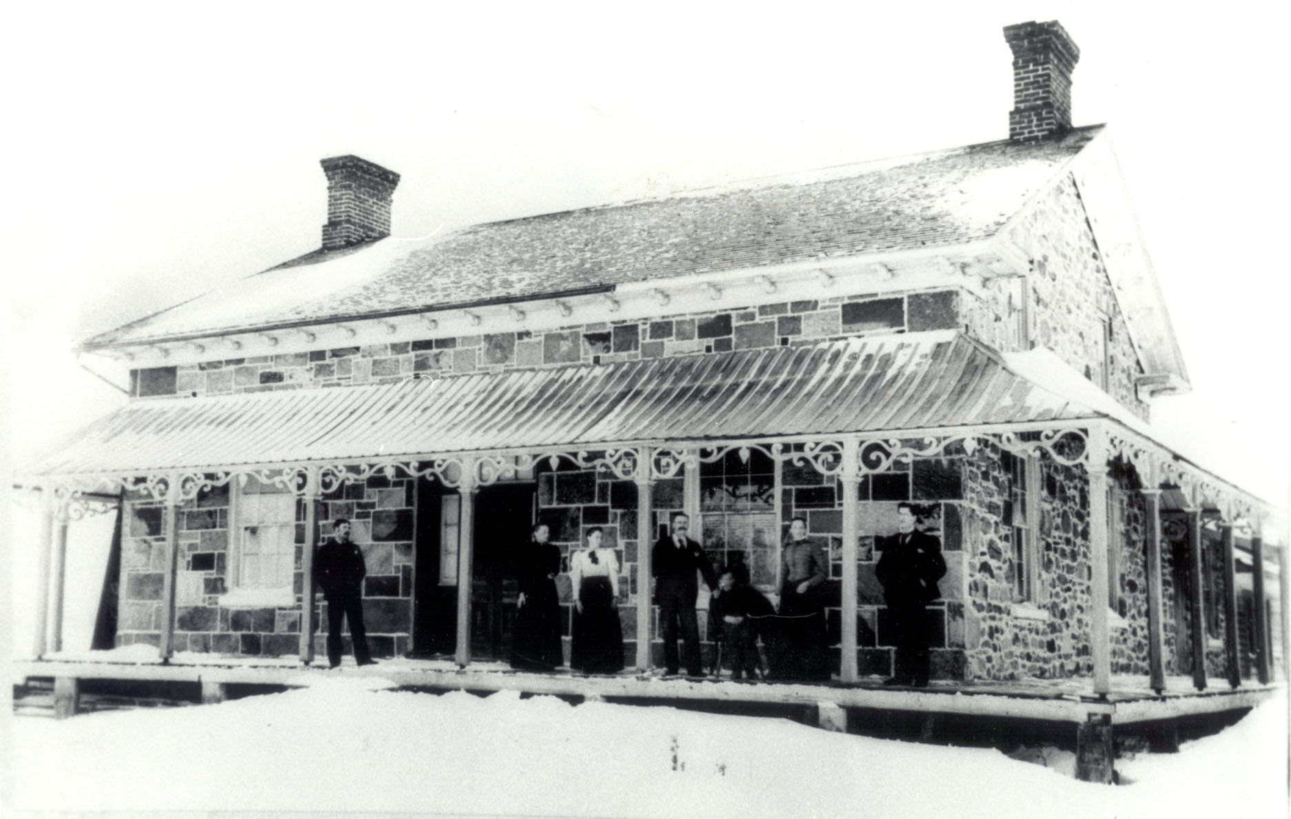 stone house from 1868 with family posed on verandah