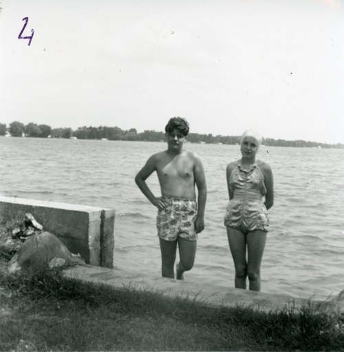 teenage boy and girl standing in lake in swimsuits from the 1950s