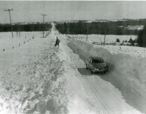 man standing on top of a snow bank 