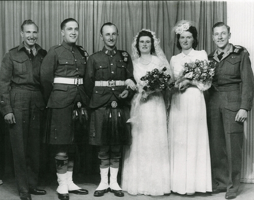 group photo of three men in military uniform, two women one bride and one bridesmaid