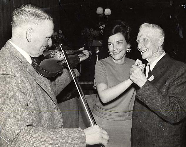 man plays violin while couple dances