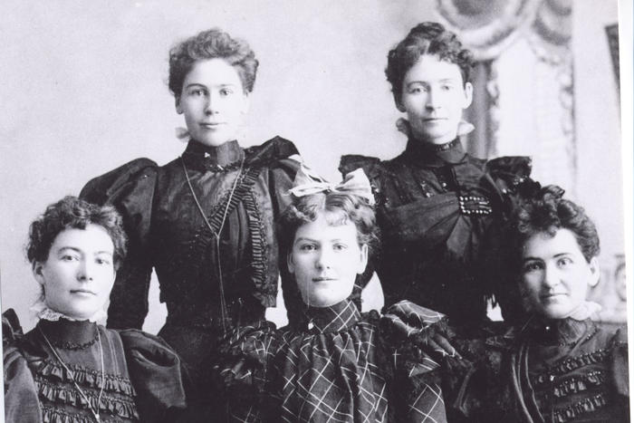 Black and white portrait of 5 sisters in 1885. Three are seated, two standing.