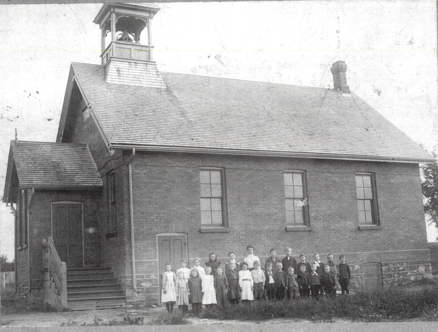 one room school house with close posed outside