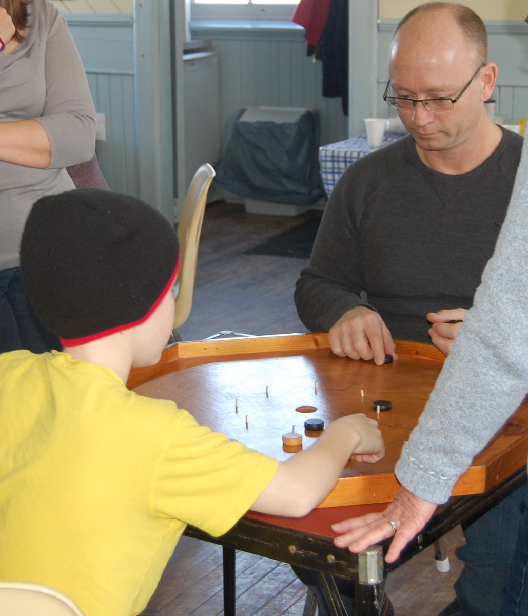 Father and son play crokinole
